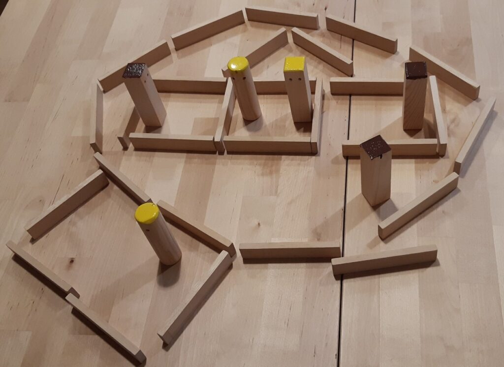Cliënt werkt met poppetjes en latjes tijdens een ik-grensopstelling, om persoonlijke grenzen en innerlijke ruimte te onderzoeken en herstellen